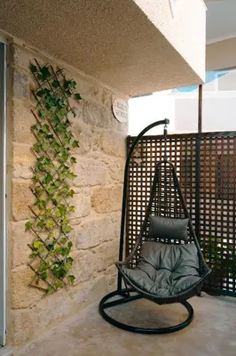 a black swing sitting next to a stone wall at Kiki's House near Falassarna and Balos in Plátanos
