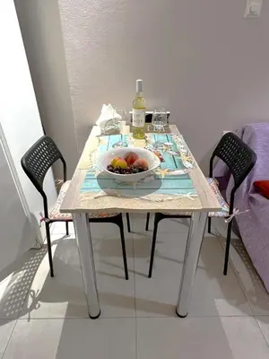 a table with a bowl of fruit and a bottle of wine at Marial City Apartment Chania in Chania Town