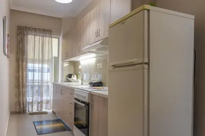 a kitchen with a white refrigerator and a window at Marial City Apartment Chania in Chania Town