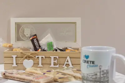 a table with a cup of coffee and a box of tea at Marial City Apartment Chania in Chania Town