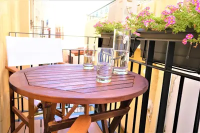 a wooden table on a balcony with glasses on it at The Journey Design Home Chania in Chania Town