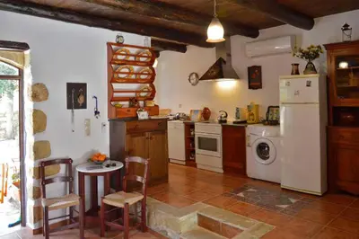 a kitchen with a white refrigerator and a table and chairs at Apanemia in Vamos