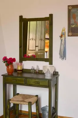 a wooden dressing table with a mirror on a wall at Apanemia in Vamos