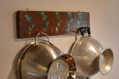 a metal pot hanging on a wall with a wooden plaque at Apanemia in Vamos