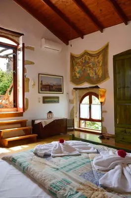 a bedroom with a large bed and a fireplace at Apanemia in Vamos