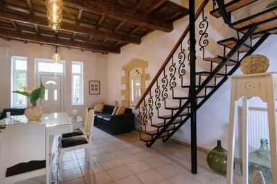 a living room with a spiral staircase in a house at Diogenis Residence Euphoria in Arménoi