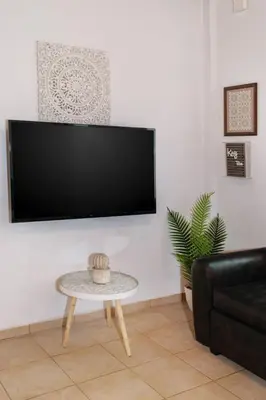a living room with a table and a flat screen tv at Diogenis Residence Euphoria in Arménoi