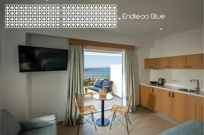 a kitchen and a living room with a table and chairs at Endless Blue in Palaiochóra