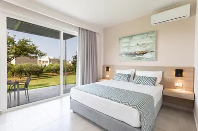 a bedroom with a bed and a large window at Twins Apartments in Plataniás