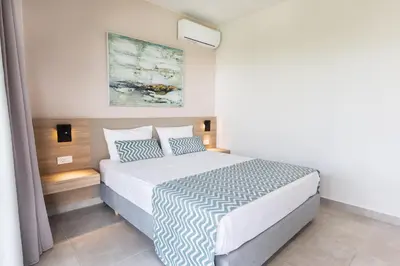 a bedroom with a large bed with blue and white sheets at Twins Apartments in Plataniás