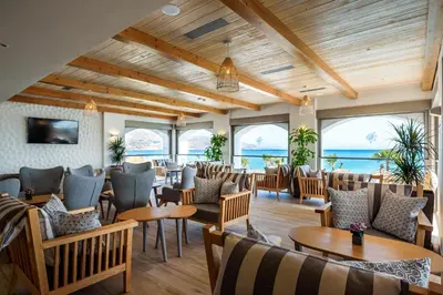 a restaurant with tables and chairs and the ocean at Solimar White Pearl - Adults Only in Kolymvari