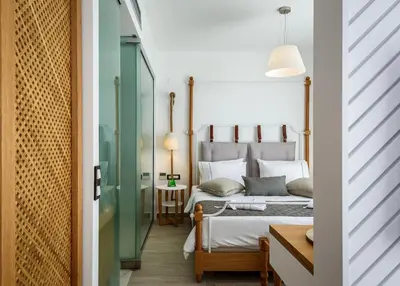a bedroom with a bed and a table at Solimar White Pearl - Adults Only in Kolymvari