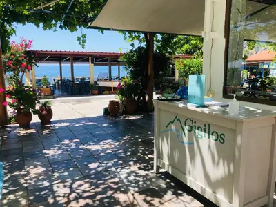 a restaurant counter with a view of the ocean at Gigilos in Agia Roumeli