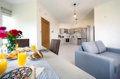 a dining room with a table with food and a couch at Alexandra Apartment in Daratso