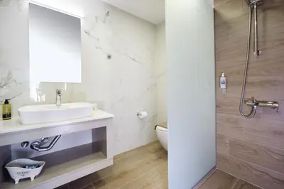 a white bathroom with a sink and a shower at Alexandra Apartment in Daratso