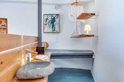 a room with a bench and a rock on the floor at Skiff - Transformed studio on the water's edge in Chania Town