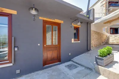 a house with a wooden door on the side of it at Skiff - Transformed studio on the water's edge in Chania Town