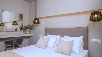a bedroom with a white bed with white pillows at Fata Morgana Studios & Apartments in Frangokastello