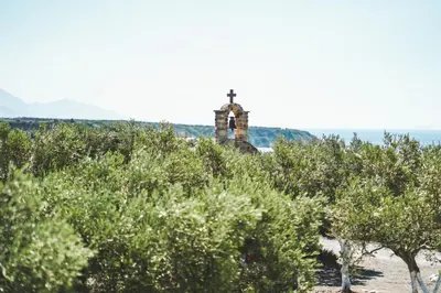 a church on top of a hill with trees at Fata Morgana Studios & Apartments in Frangokastello
