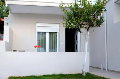 a white house with a tree in front of it at Cosy Apartments Daphne in Daratso