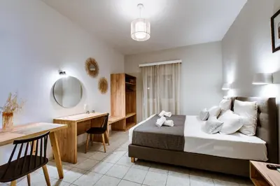 a hotel room with a bed and a desk at Koulouris Apartments & Studios in Kalyves