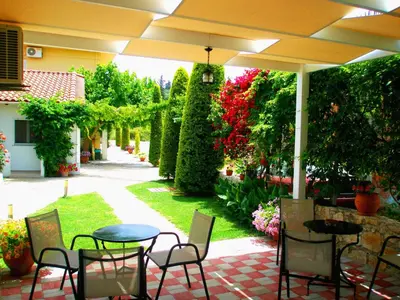 a patio with tables and chairs under an umbrella at Koulouris Apartments & Studios in Kalyves
