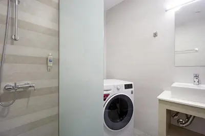 a bathroom with a washing machine and a sink at Ariadne Apartment in Daratso
