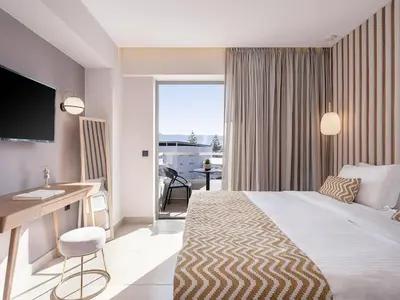 a hotel room with a large bed and a desk and a desk at M City Hotel in Chania Town