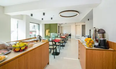 a cafeteria with a row of tables and chairs at M City Hotel in Chania Town
