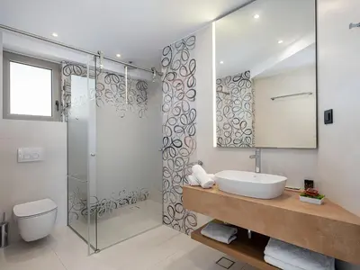 a bathroom with a sink and a glass shower at M City Hotel in Chania Town