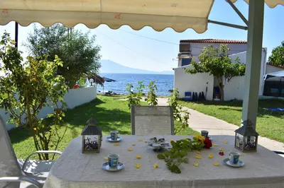a table with food and a view of the ocean at House just on the beach -included 2 canoe and 2 bicycles in Ravdhoúkha