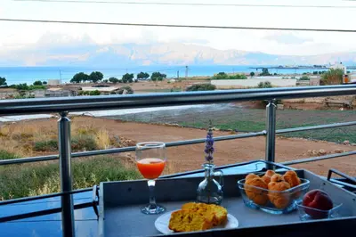 a table with a plate of food and a glass of orange juice at Balos Residence private pool Seafront Seaview in Kissamos