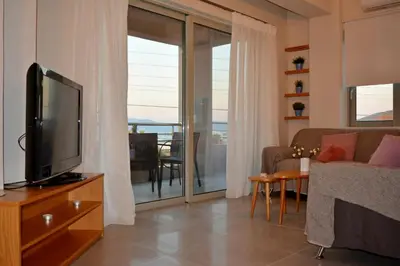 a living room with a flat screen tv and a couch at Balos Residence private pool Seafront Seaview in Kissamos