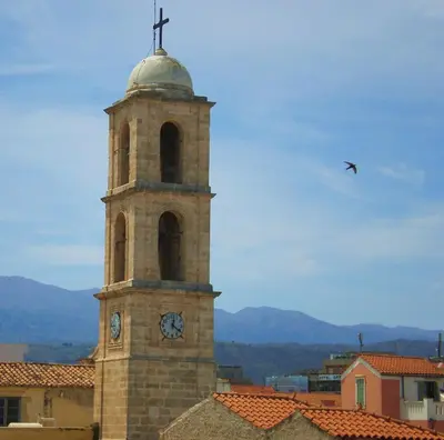 a clock tower with a cross on top of a building at Palazzo di Pietro in Chania Town