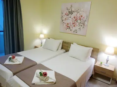 two beds in a hotel room with flowers on them at Marias Apartment in Chania Town
