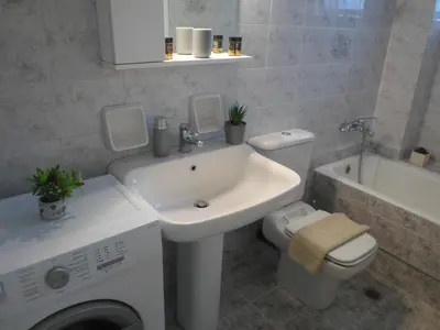 a bathroom with a sink toilet and a washing machine at Marias Apartment in Chania Town