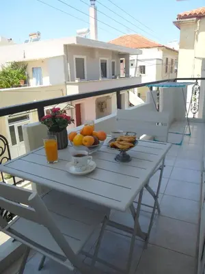 a white table with a bowl of fruit on a balcony at Marias Apartment in Chania Town