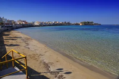 a beach with a yellow sign on the shore at Marias Apartment in Chania Town