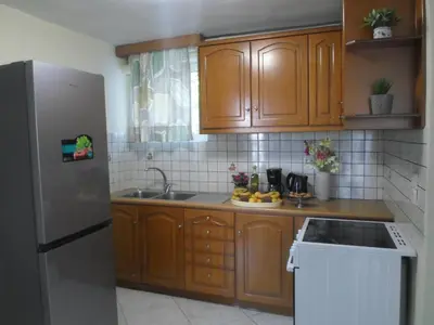 a kitchen with wooden cabinets and a stainless steel refrigerator at Marias Apartment in Chania Town
