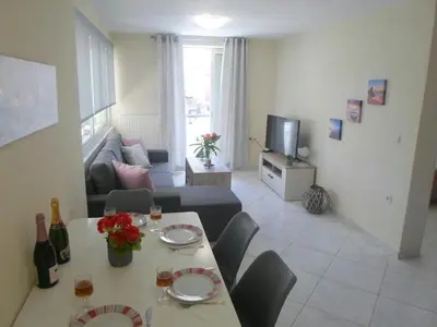 a living room with a table and chairs and a couch at Marias Apartment in Chania Town
