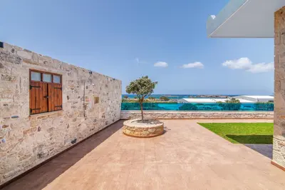 a courtyard with a tree in the middle of a building at Dream Sea House villa Falassarna in Falasarna