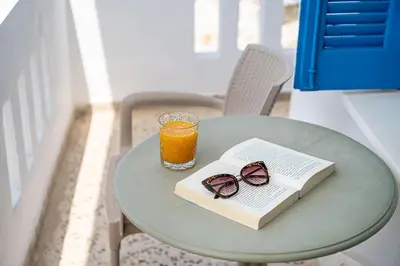 a book and glasses on a table with a drink at Lefka Ori in Khóra Sfakíon