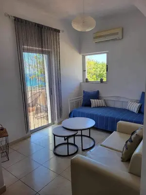a living room with a couch and a table at 180 Degree Sea View Apartment in Palaiochóra