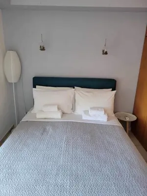 a bed with two pillows and a blue head board at 180 Degree Sea View Apartment in Palaiochóra