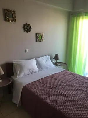 a bedroom with a bed and a green curtain at 180 Degree Sea View Apartment in Palaiochóra