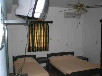 a room with two beds and a ceiling fan at CAPTAIN GEORGE in Sougia