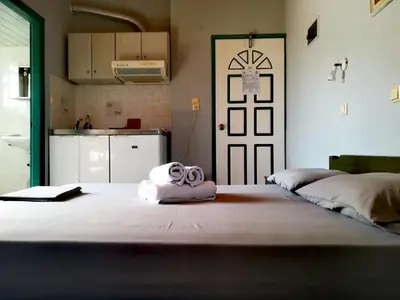 a room with a bed with two rolled towels on it at CAPTAIN GEORGE in Sougia