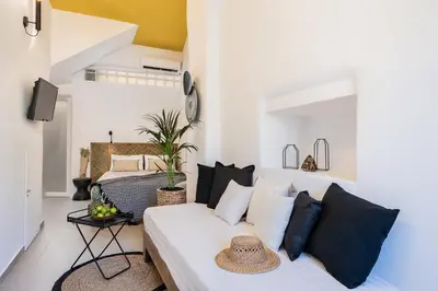 a bedroom with a bed with black and white pillows at Artemide city places-Cozy Rooms in Chania Town