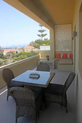 a balcony with a table and chairs and a couch at Effi Apartments in Plataniás