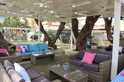 a patio with couches and tables and trees at Effi Apartments in Plataniás